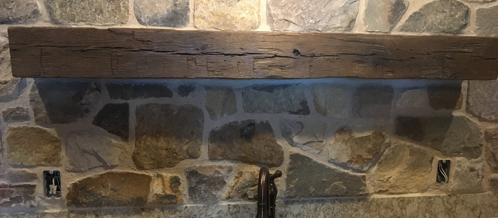 Reclaimed wood mantle above a sink.