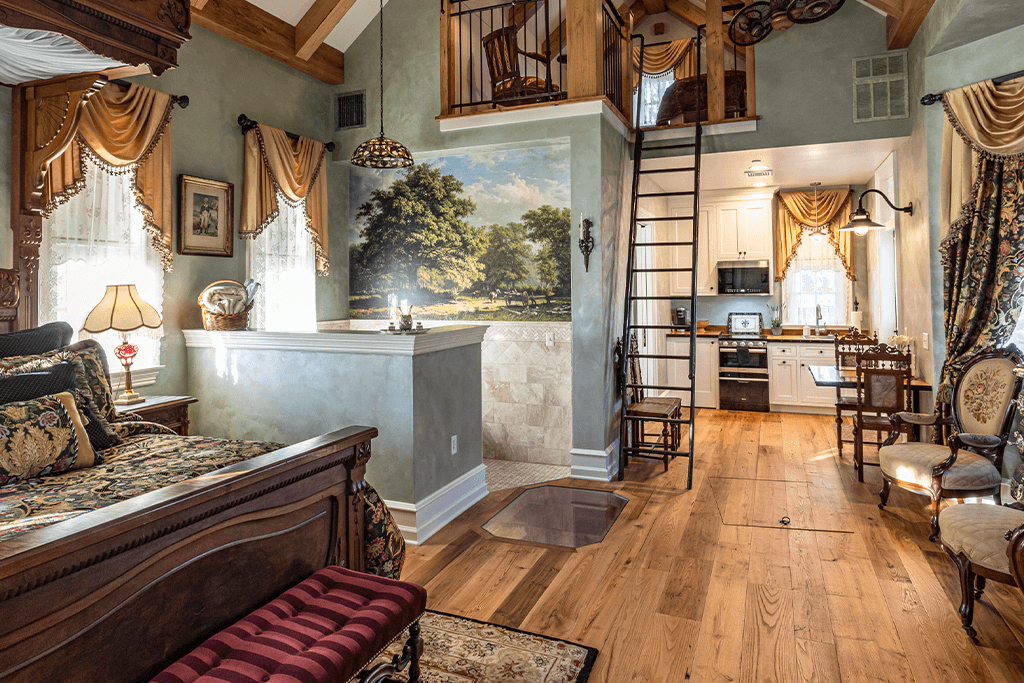 a bedroom with reclaimed wood flooring and a landscape painting on the wall