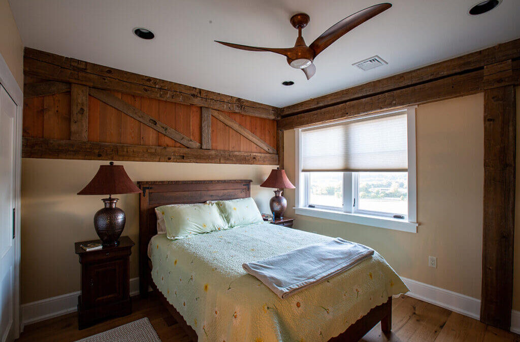 A cottagecore interior design bedroom with wooden wall planking and a wooden headboard.