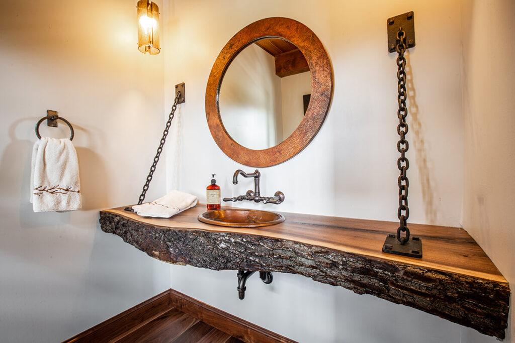 a live edge wood bathroom sink counter with a circular mirror