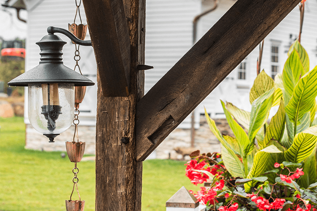 A wooden porch post with a lantern hanging from it