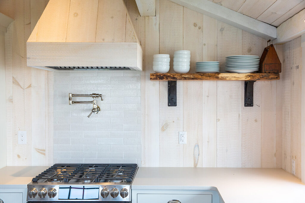 cottagecore interior design kitchen with white wood paneling and wooden shelves