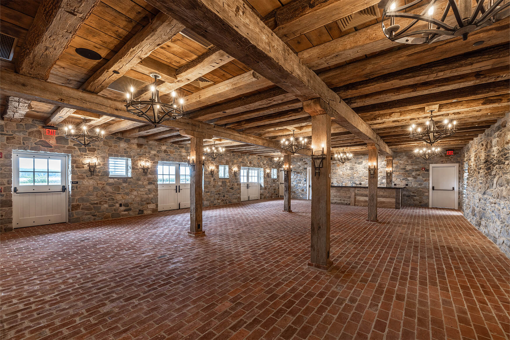 Reclaimed box beams along the ceiling of a stone room