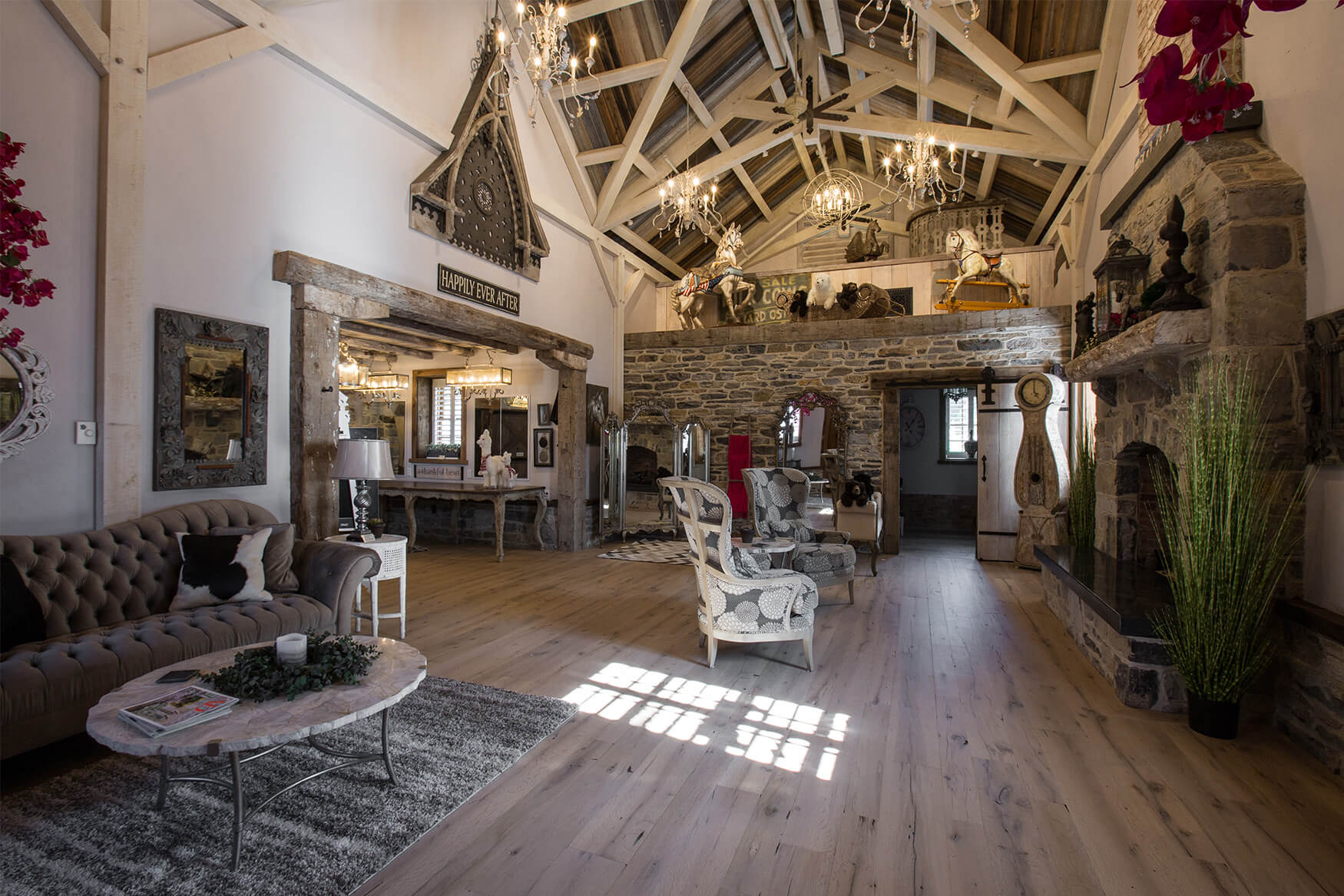 living room with reclaimed wood flooring, a couch, chairs, and more
